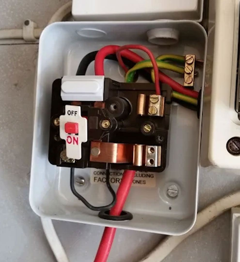 Open isolator switch enclosure showing meter tails, earth block and copper busbars