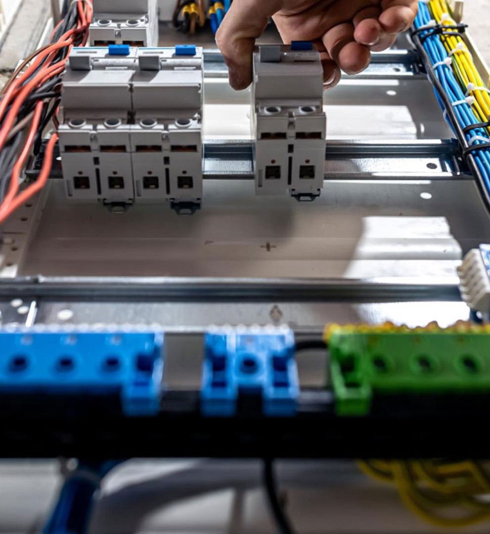 Hand clipping a circuit breaker onto the rail inside a consumer unit