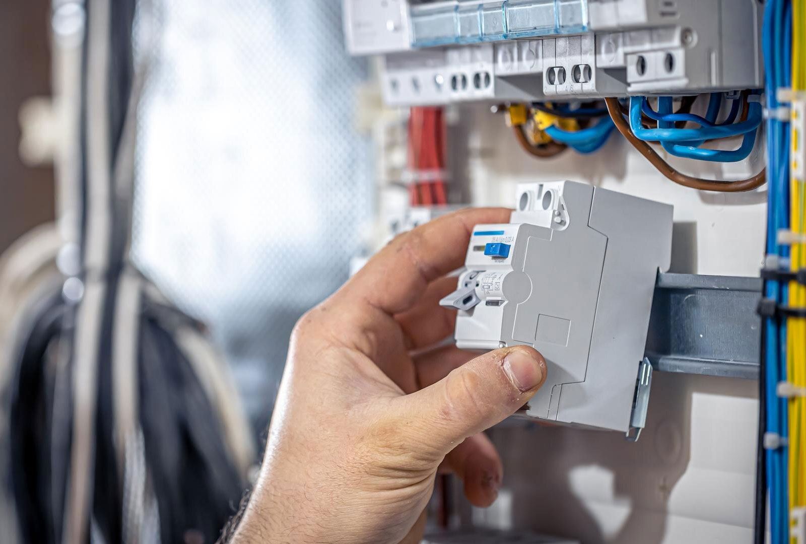 Technician holds an RCD module in front of an open consumer unit