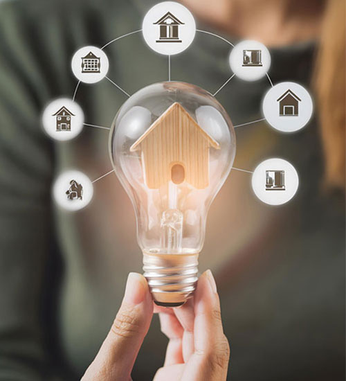 Hand holding a bulb surrounded by smart home control icons