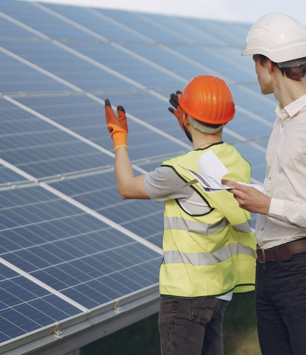 Site worker points out panels to a colleague holding documents